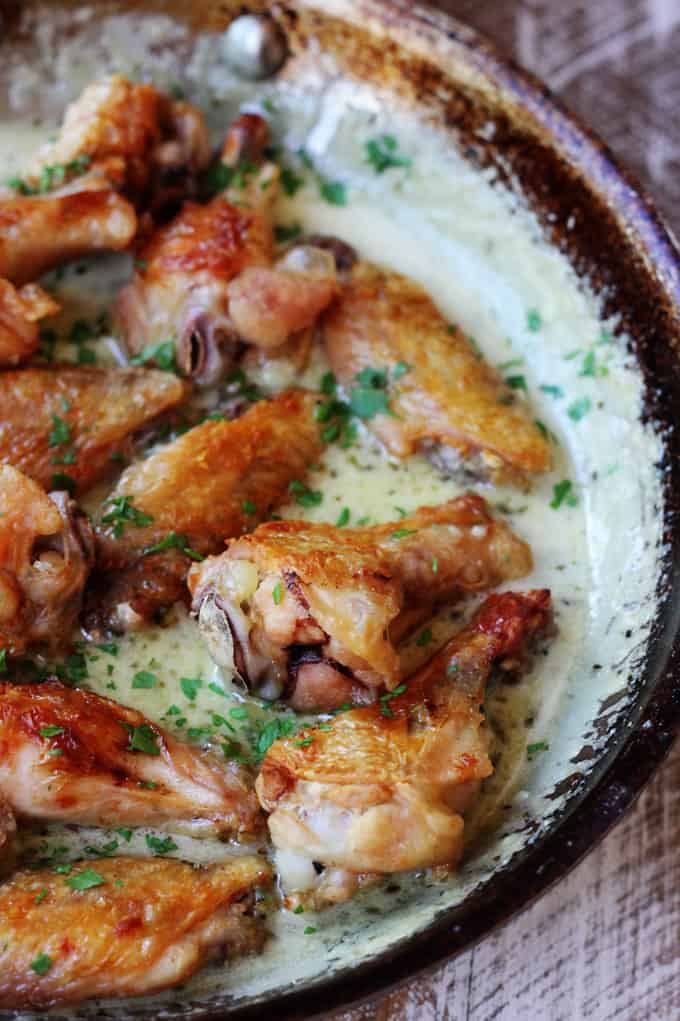 Chicken wings with garlic parmesan sauce in a skillet