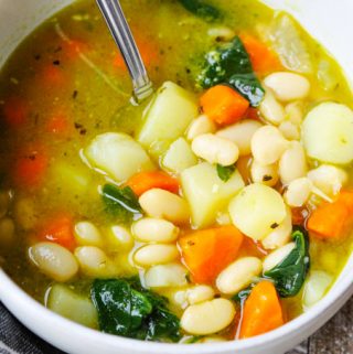 Bean Soup with spinach and pesto from pressure cooker served in a bowl