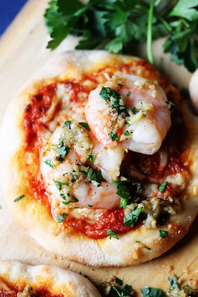 Pizzette with Garlic Shrimp and Roasted Pepper Pesto on a pizza peel