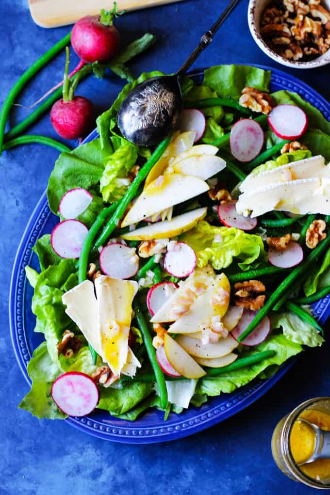 French Salad with Beans, Radishes, Cheese, Pears on a blue serving plate 