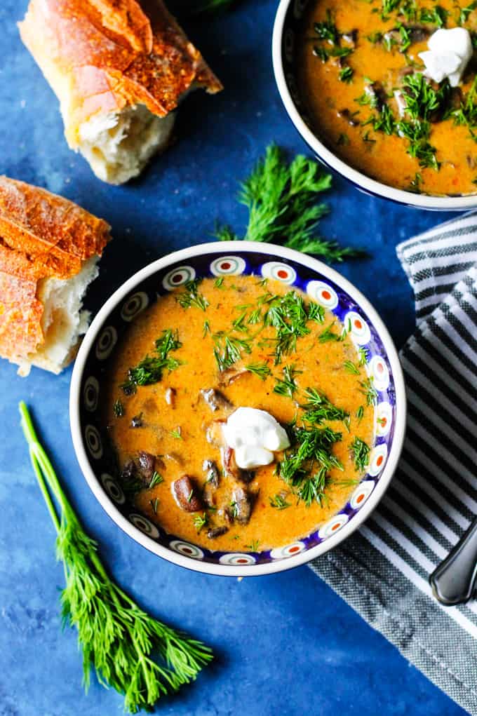 Hungarian Mushroom Soup with fresh dill in bowls and bread on a side