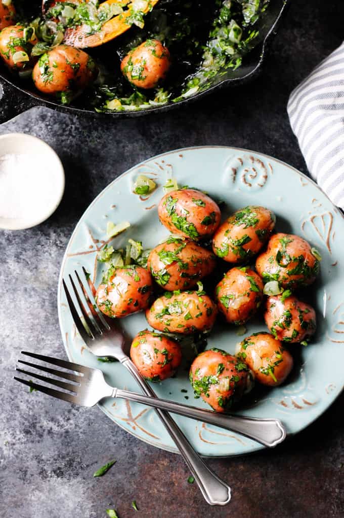 Parsley potatoes on a blu plate with forks