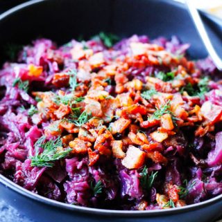 Horizontal shot of red braised cabbage in a bowl with spoon
