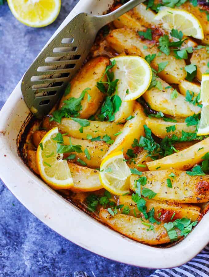 Greek Lemon Potatoes in baking dish with spatula