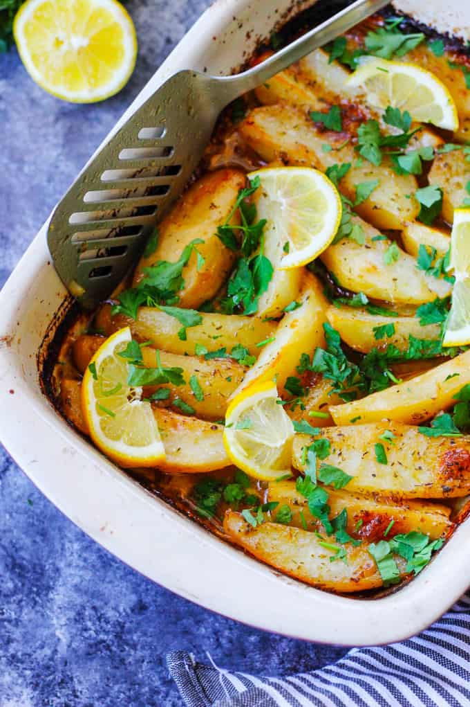 Greek Lemon Potatoes in baking dish with spatula