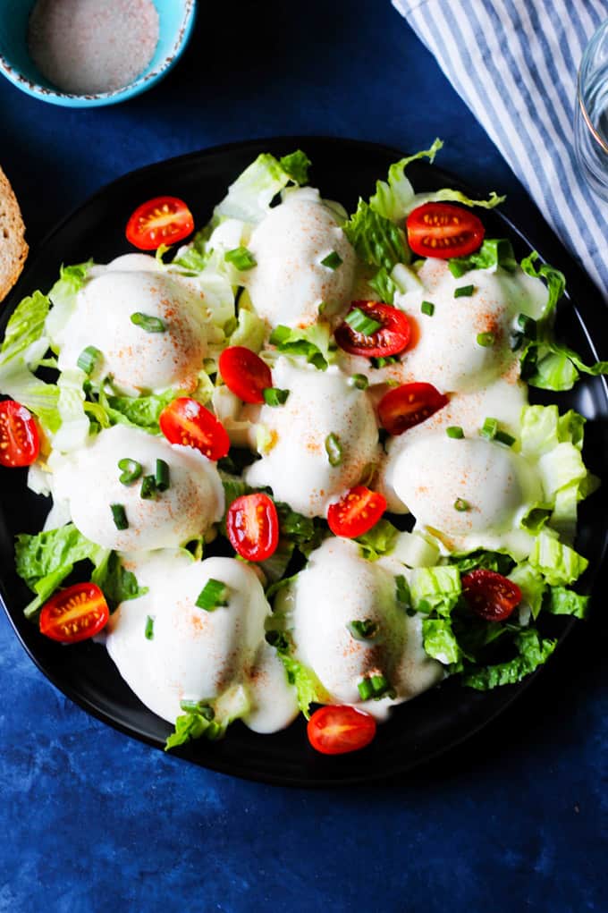 Eggs Mayonnaise on a serving plate garnished with tomatoes and green onions