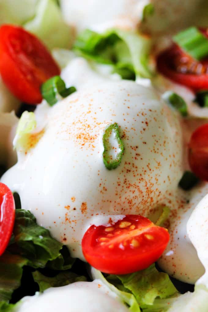 Close up photo of Eggs Mayonnaise with cherry tomatoes and scallions