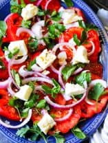 Tomato Feta Salad with herbs on a blue serving plate