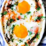 Baked eggs in cream tomato spinach sauce in white ramekin