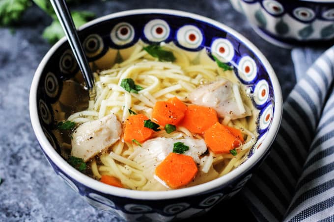 Horizontal photo of a Polish Chicken Soup in a bowl with spoon