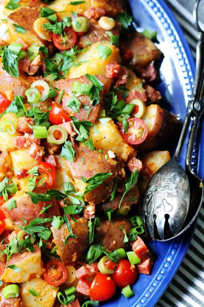 Close up vertical photo of Spanish Potato Salad with Olives, Tomatoes and Chorizo
