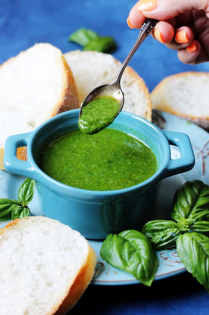 Basil sauce in a blue ramekin with spoon