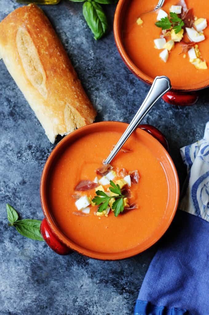 Overhead photo of Salmorejo Spanish Cold Tomato Soup in bowls with bread on a side