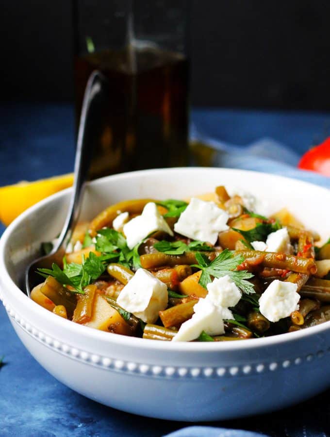 Greek Green Beans in a white bowl with feta