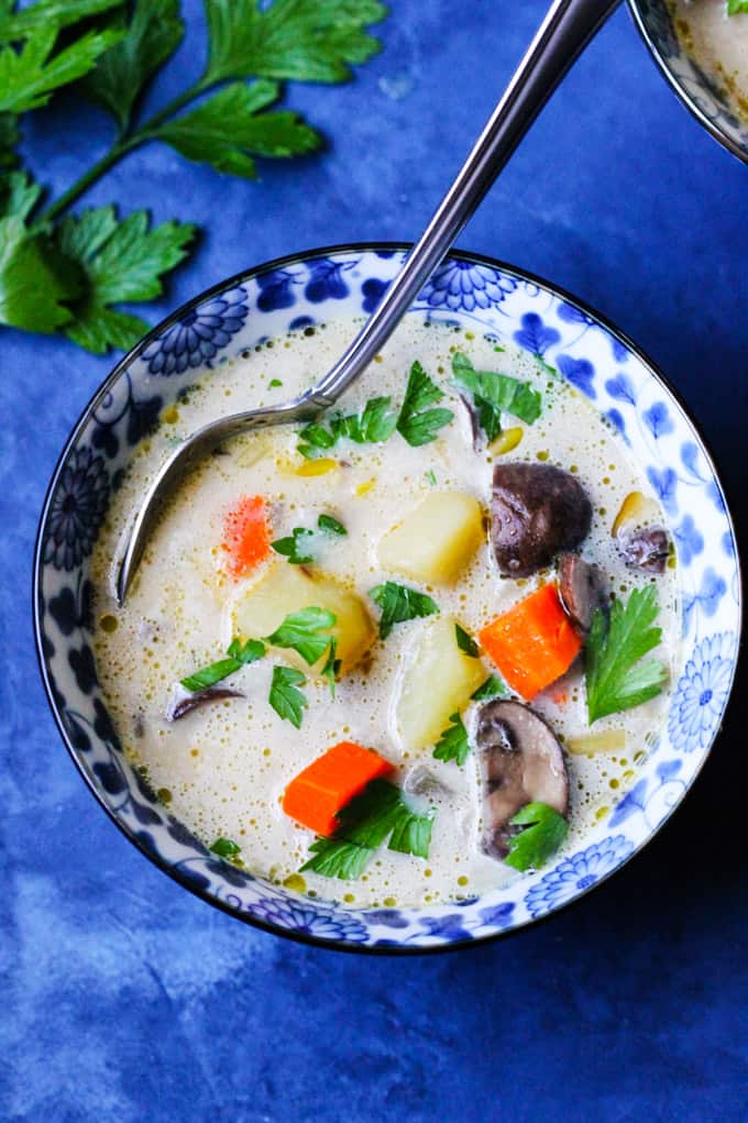 Polish Mushroom soup in a blue bowl with spoon