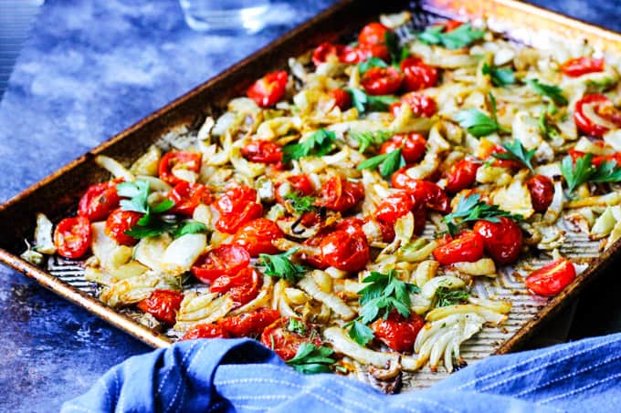 Roasted fennel with tomatoes on a cookie sheet