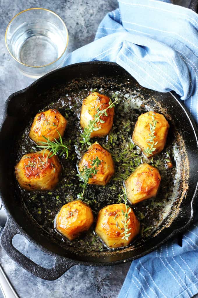 Fondant Potatoes in cast iron skillet with herbs