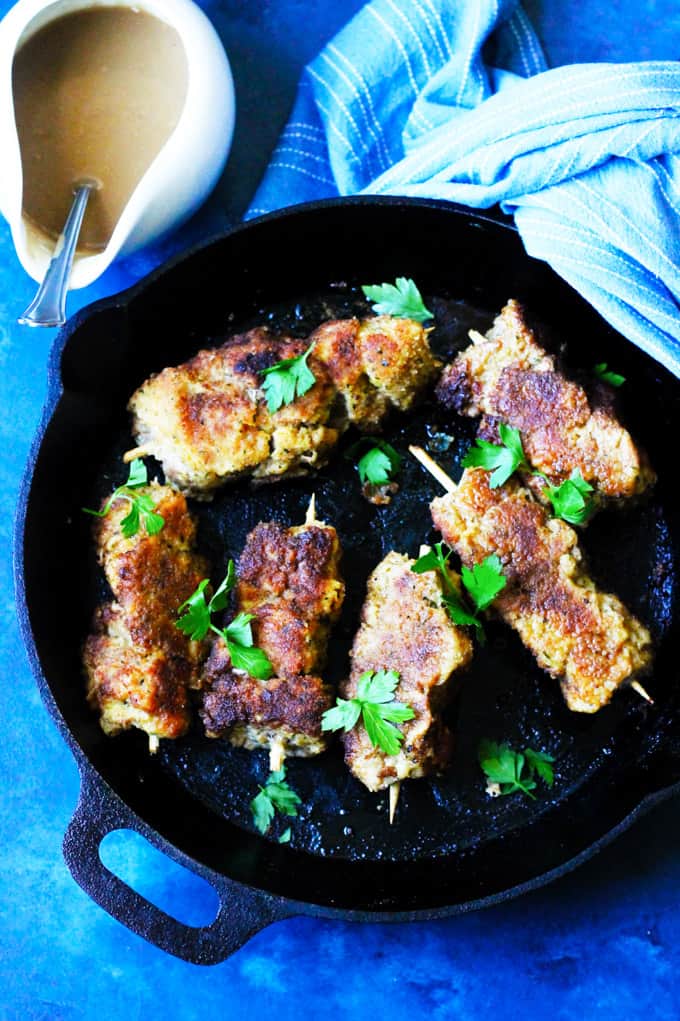 Breaded pork on skewers in cast iron pan