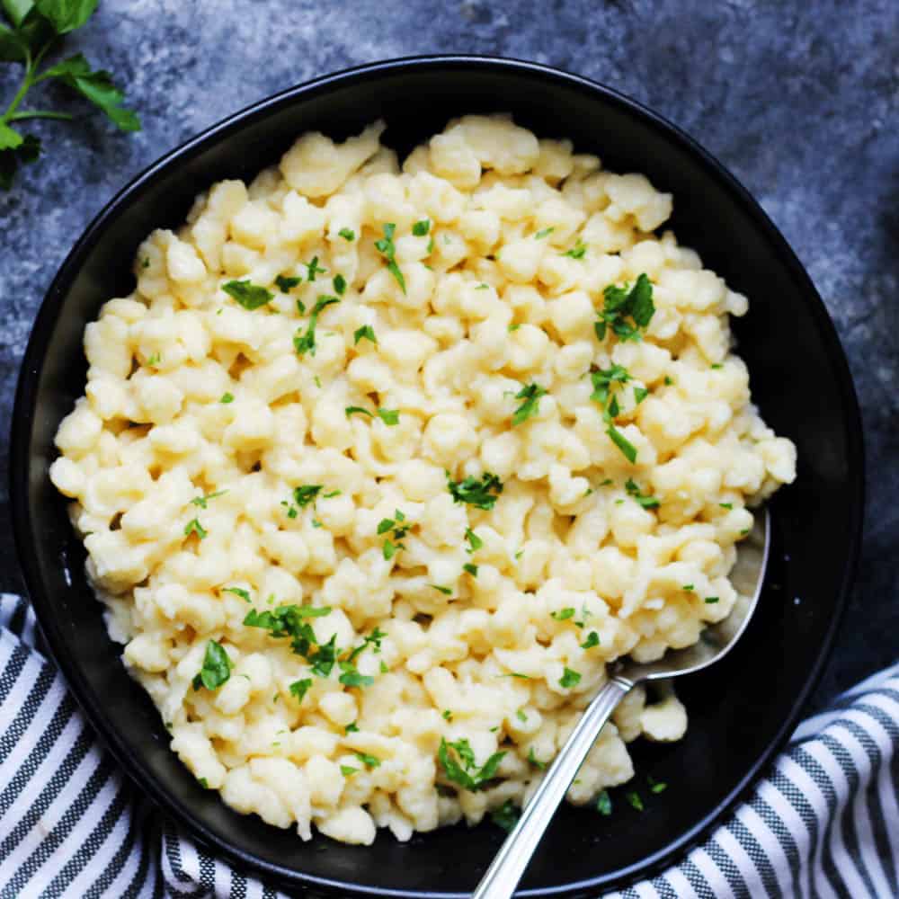 Nokedli in a black bowl with spoon