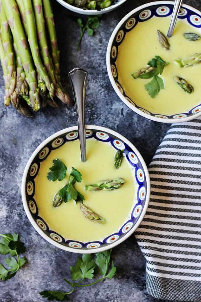 Two Bowls of Green Asparagus Soup with spoons