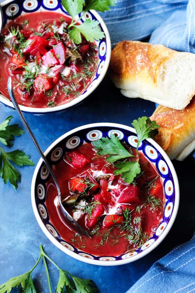 Two bowls of Polish Young Beet Soup with bread on a side