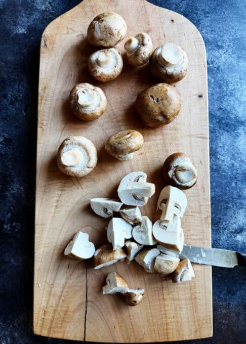 Mushrooms being chopped up on a cutting board