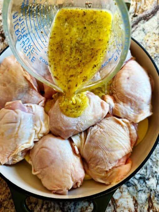 Sauce is being poured over the chicken and potatoes