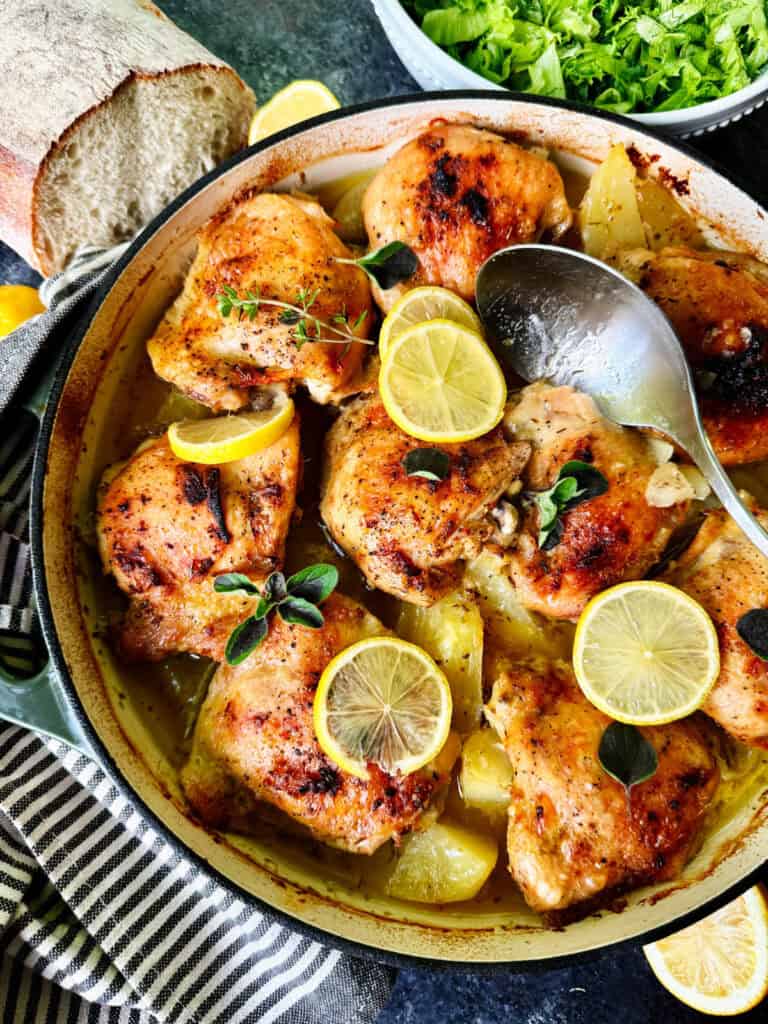 Spooning pan juices over Greek lemon potatoes chicken