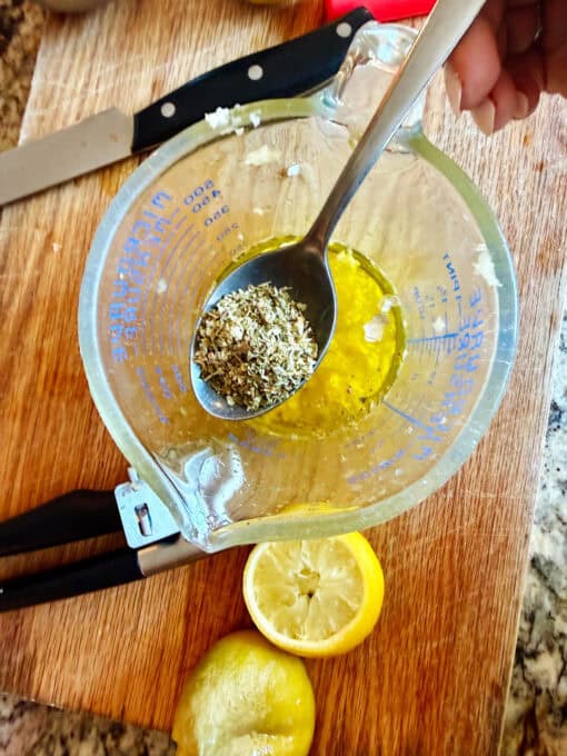 Spoon of seasoning being added to the bowl