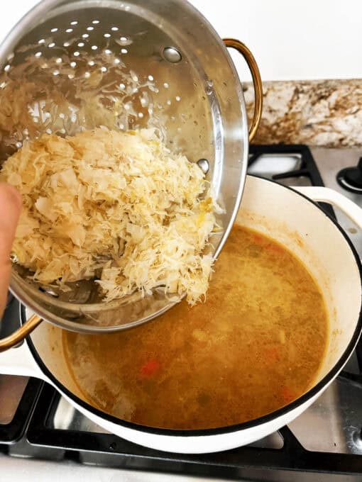Sauerkraut being added to the soup