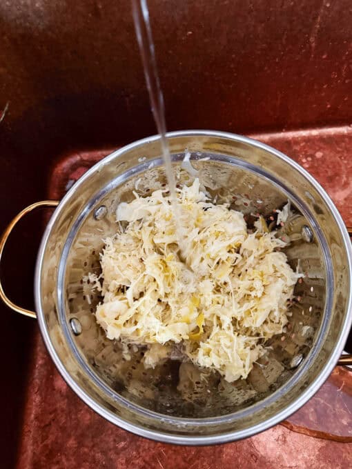 Sauerkraut being rinsed in a colander